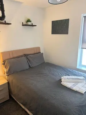 a bedroom with a bed with a gray bedspread and a window at 1 Double Bedroom Apartment Central Blackpool 4 in Blackpool