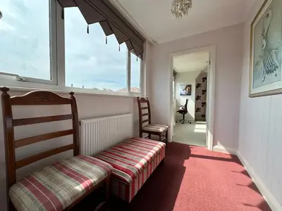 a small room with a bench and a window at Birkdale Open - Four Bed Home in Southport