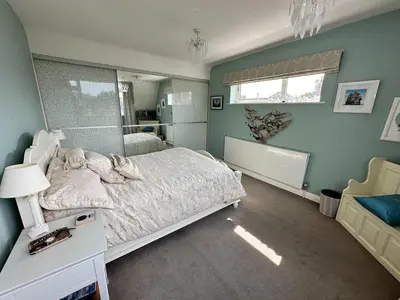 a bedroom with a large bed and a window at Birkdale Open - Four Bed Home in Southport