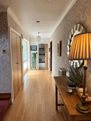a living room with a table with a lamp on it at Birkdale Open - Four Bed Home in Southport