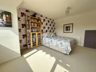 a bedroom with a bed and a book shelf at Birkdale Open - Four Bed Home in Southport