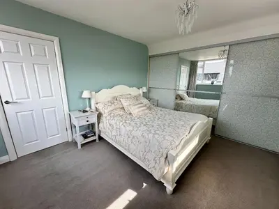 a bedroom with a white bed and a mirror at Birkdale Open - Four Bed Home in Southport