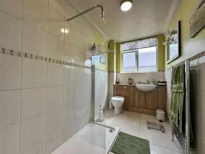 a bathroom with a tub and a toilet and a sink at Birkdale Open - Four Bed Home in Southport