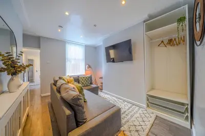 a living room with a couch and a tv at Stunning 1 Bedroom 4 Guest Flat by Anfield Stadium in Liverpool