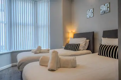 a bedroom with two beds with towels on them at Stunning 1 Bedroom 4 Guest Flat by Anfield Stadium in Liverpool