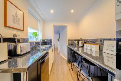 a large kitchen with granite counter tops at Stunning 1 Bedroom 4 Guest Flat by Anfield Stadium in Liverpool
