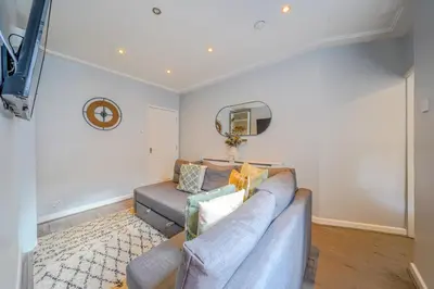 a living room with a couch and a tv at Stunning 1 Bedroom 4 Guest Flat by Anfield Stadium in Liverpool