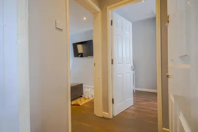 a hallway with a white door and a television at Stunning 1 Bedroom 4 Guest Flat by Anfield Stadium in Liverpool