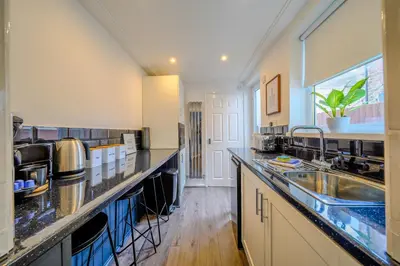 a large kitchen with a sink and a counter at Stunning 1 Bedroom 4 Guest Flat by Anfield Stadium in Liverpool