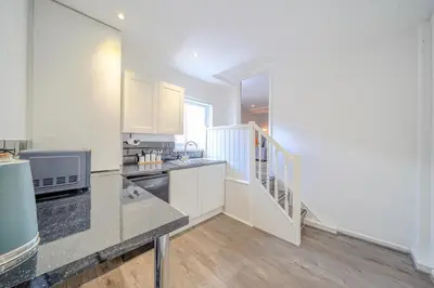 a kitchen with white cabinets and a counter top at Stunning 2 Bedroom 6 Guest Flat by Anfield Stadium in Liverpool
