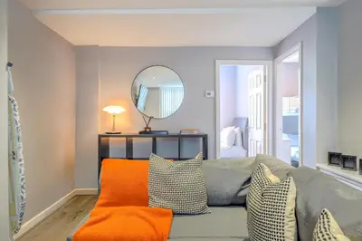 a living room with a couch and a mirror at Stunning 2 Bedroom 6 Guest Flat by Anfield Stadium in Liverpool