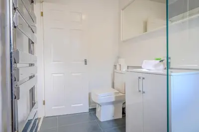 a white bathroom with a toilet and a glass door at Stunning 2 Bedroom 6 Guest Flat by Anfield Stadium in Liverpool
