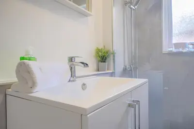 a white bathroom with a sink and a shower at Stunning 2 Bedroom 6 Guest Flat by Anfield Stadium in Liverpool