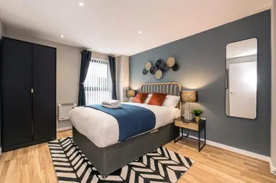 a bedroom with a large bed and a mirror at Central 2 Beds with Free Parking in Liverpool