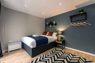 a bedroom with a bed and a blue wall at Central 2 Beds with Free Parking in Liverpool