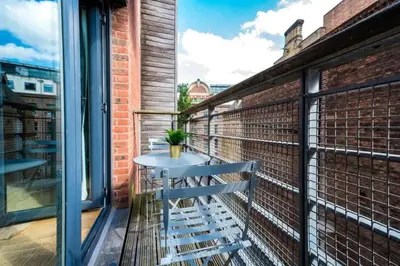 a bench on a balcony with a table at Central 2 Beds with Free Parking in Liverpool