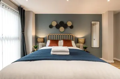 a bedroom with a large bed with two lamps at Central 2 Beds with Free Parking in Liverpool