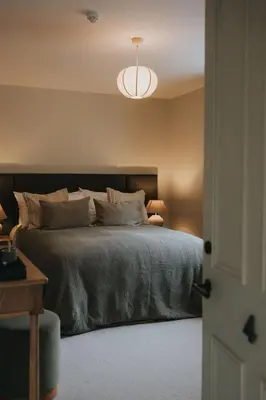 a bedroom with a bed with a black headboard at Longridge House in Longridge