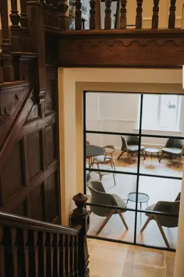 a room with chairs and tables and a glass door at Longridge House in Longridge