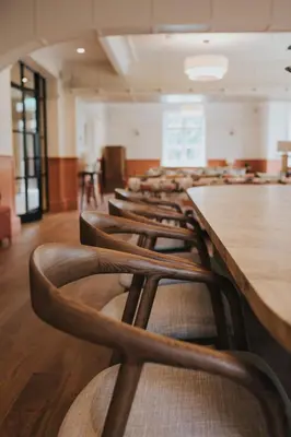 an empty room with a row of tables and chairs at Longridge House in Longridge