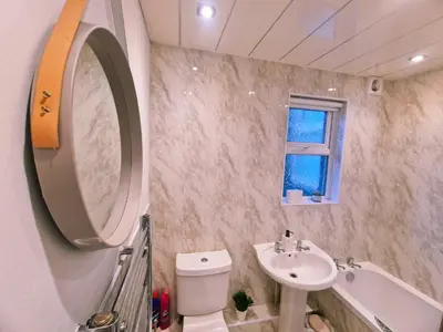 a bathroom with a sink and a toilet and a mirror at 5 star Luxury Home by Liverpool Football Stadium in Liverpool