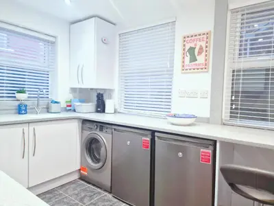 a kitchen with a washer and dryer at 5 star Luxury Home by Liverpool Football Stadium in Liverpool