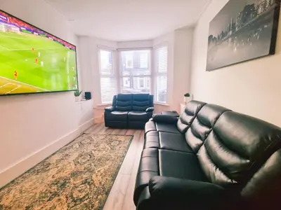 a living room with a couch and a tv at 5 star Luxury Home by Liverpool Football Stadium in Liverpool