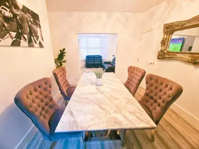 a dining room with a table with chairs and a mirror at 5 star Luxury Home by Liverpool Football Stadium in Liverpool