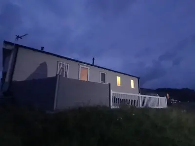 a house with lights on the side of it at night at The Seaflower - With Lake Views in Millom