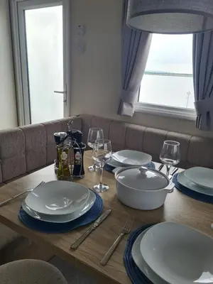 a wooden table with plates and wine glasses on it at The Seaflower - With Lake Views in Millom