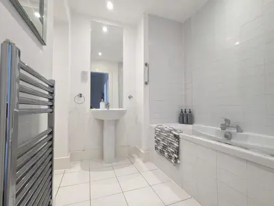 a white bathroom with a sink and a tub and a sink at Elegant Apartment in Hamilton Square Free Parking in Birkenhead