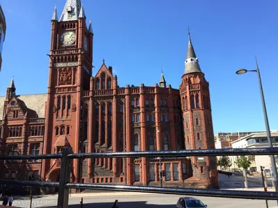 a large brick building with a clock tower at Elegant Apartment in Hamilton Square Free Parking in Birkenhead