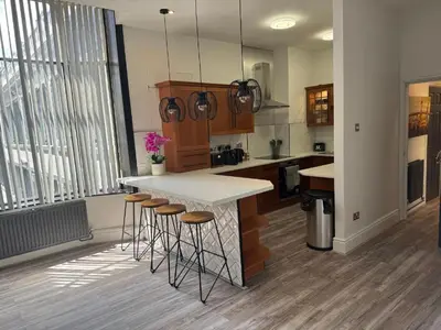 a kitchen with a counter and stools in a room at Luxury Double Liverpool City Centre Penthouses 8 Guests in Liverpool