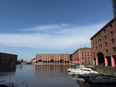 a group of boats docked in a river with buildings at Luxury Double Liverpool City Centre Penthouses 8 Guests in Liverpool