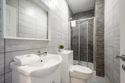a white bathroom with a sink and a toilet at Two Apartments in One , City Centre, Sleeps 11! in Liverpool
