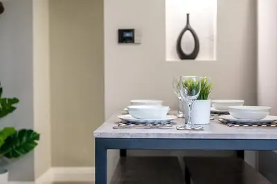 a dining room table with bowls and plates on it at Two Apartments in One , City Centre, Sleeps 11! in Liverpool