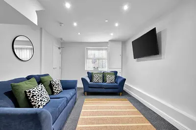 a living room with two blue couches and a flat screen tv at Kemble House - Air Host & Stay - 5 Bedroom, 5 Bathroom - Sleeping 10 in Prescot