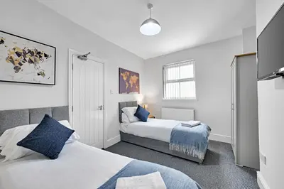 a bedroom with two beds and a window at Kemble House - Air Host & Stay - 5 Bedroom, 5 Bathroom - Sleeping 10 in Prescot