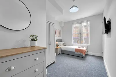 a bedroom with a bed and a large window at Kemble House - Air Host & Stay - 5 Bedroom, 5 Bathroom - Sleeping 10 in Prescot