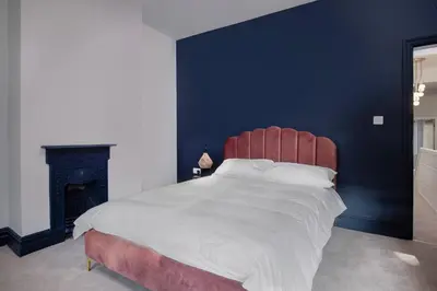 a bedroom with a large bed with a red headboard and a fireplace at Blackpool Beauty! - Full House - Sleeps 9 in Blackpool