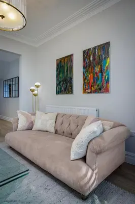 a couch in a living room with two paintings on the wall at Blackpool Beauty! - Full House - Sleeps 9 in Blackpool