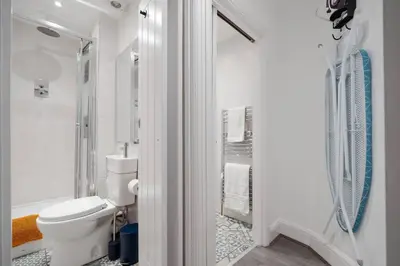 a white bathroom with a toilet and a shower at Anfield Abode in Liverpool