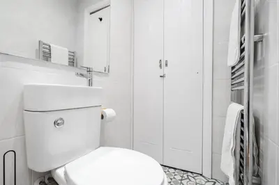 a white bathroom with a toilet and a shower at Anfield Abode in Liverpool