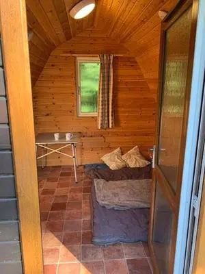 a log cabin with a bed in a room at Woodland Camping Pod in Hale