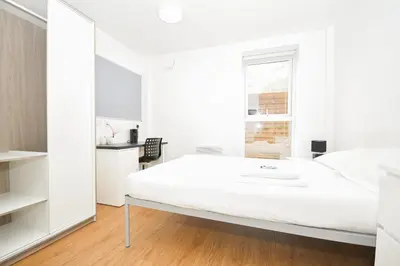 a white bedroom with a bed and a mirror at Spacious 6 Bedroom Apartment in Liverpool in Liverpool