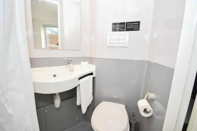 a small bathroom with a sink and a toilet at Spacious 6 Bedroom Apartment in Liverpool in Liverpool