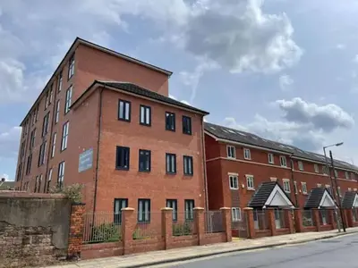 a brick building with a fence in front of it at Spacious 6 Bedroom Apartment in Liverpool in Liverpool