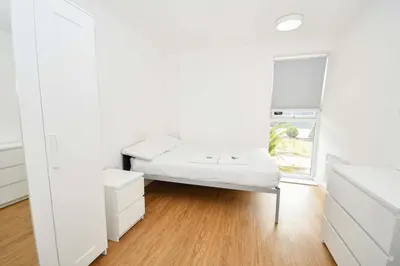 a white room with a bed and a window at Convenient 8 Bedroom Apartment in Liverpool in Liverpool