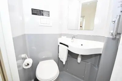 a bathroom with a sink and a toilet and a mirror at Convenient 8 Bedroom Apartment in Liverpool in Liverpool