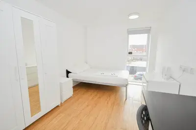 a white room with a couch and a window at Convenient 8 Bedroom Apartment in Liverpool in Liverpool